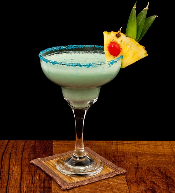Cóctel servido en una mesa con piña en el borde