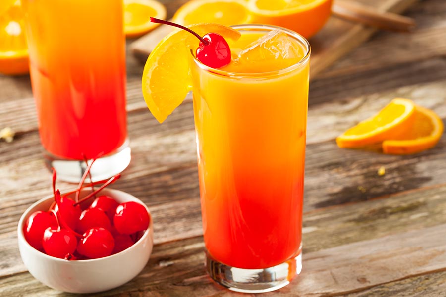 Tequila Sunrise con frutas a su alrededor
